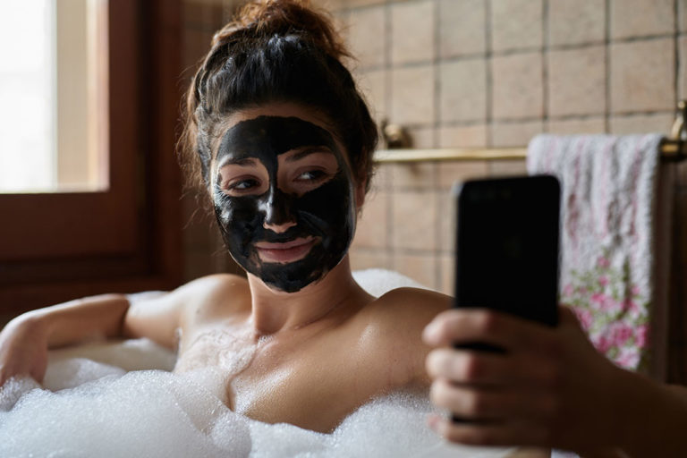 Singlemor hygger sig i badekarret med ansigtsmaske